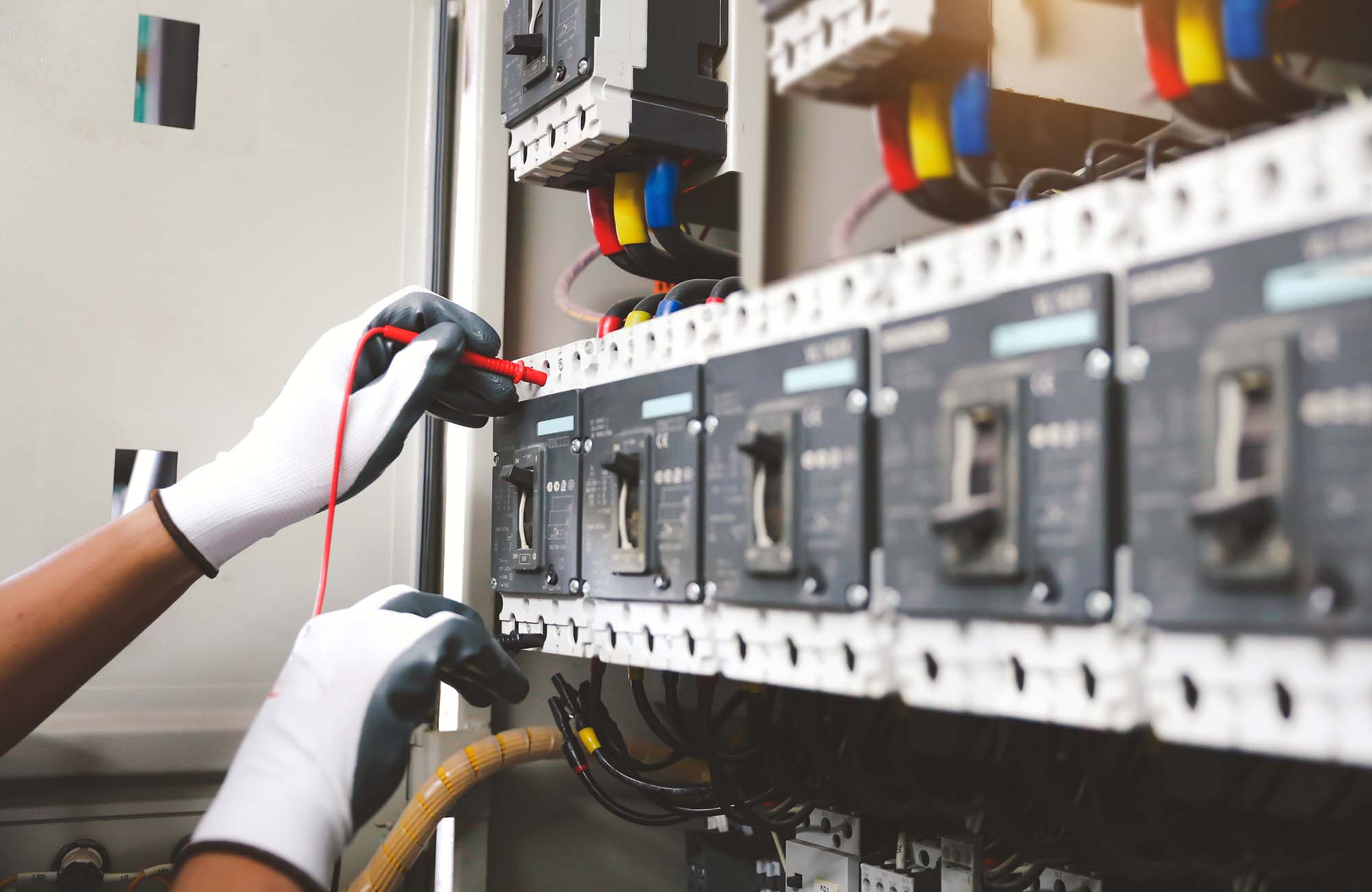 Electricity and electrical safety maintenance service system, Technician hand checking electric current voltage at circuit breaker terminal and cable wiring in main power distribution board